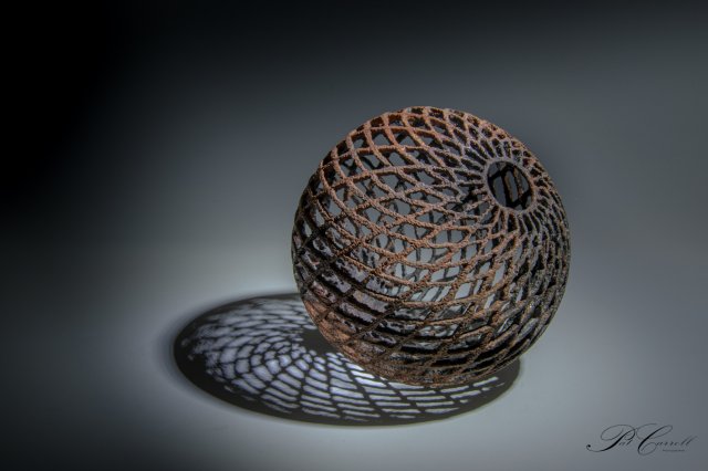 Erosion. Sycamore sphere turned to 3mm wall thickness. pierced pyrography texture. Iron paint with rust activator finish